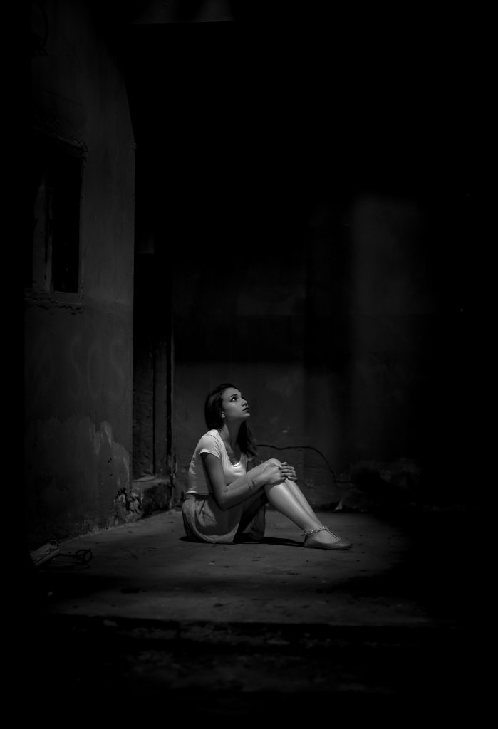 Black and White Photo of Woman Sitting Alone